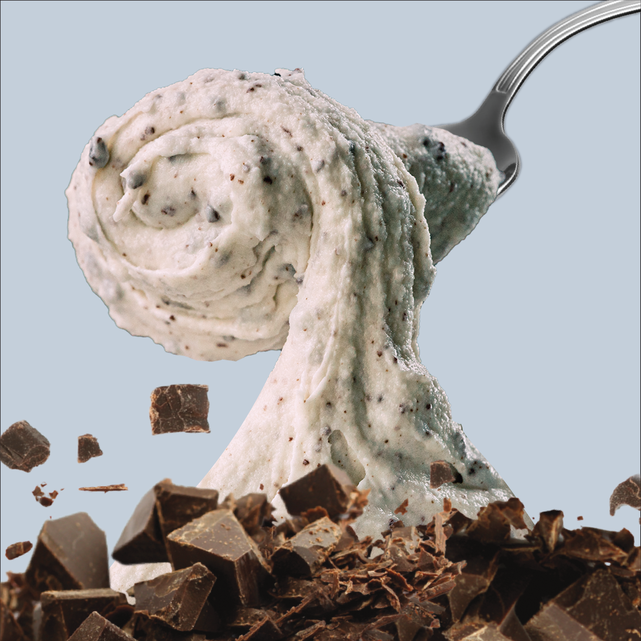 Spoonful of mint chocolate chip ice cream with chocolate pieces on a light blue background